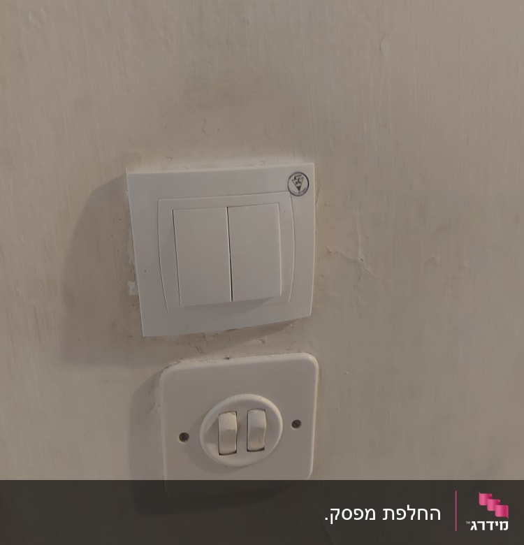 שני מתגי חשמל על קיר לבן